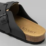 Zuecos negros con plantilla de corcho y hebilla ajustable.