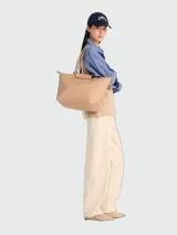 Bolso tote de tamaño grande Longchamp modelo Le Pliage One, color tostado, con doble asa de hombro y cierre superior con solapa y broche a presión.