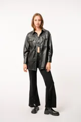 Chaqueta tipo camisa de cuero sintético color negro, con bolsillos frontales y broches metálicos.