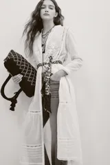 Camisa larga blanca de algodón estilo túnica, con detalles de encaje y bordados en el frente y mangas largas.