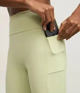 Legging deportivo de microfibra color verde claro, tiro alto, con moldería ajustada y bolsillo lateral funcional en el muslo.