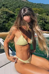 Conjunto de bikini amarillo texturizado, compuesto por un corpiño de corte triangular con tirantes finos y detalle de piedra en el centro, y una bombacha colaless con tiras laterales ajustables.
