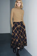 Falda midi de tiro medio con estampado de cuadros en tonos azul marino, marrón y beige. Confeccionada en hilatura con mezcla de viscosa, presenta un bajo acabado en línea evasé y cierre con cremallera oculta en la costura.