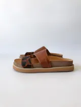 Sandalias bajas de cuero marrón con estampado animal print en las tiras.