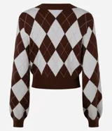 Cardigan cropped de tejido jacquard con diseño de rombos argyle en color marrón y blanco. Presenta escote en V, manga larga y cierre frontal con botones marrones.