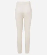 Pantalón legging color beige con frente de poliuretano que imita cuero y parte trasera de punto roma. Presenta detalle de cadena metálica en la cintura y cierre frontal.