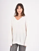 Buzo de tejido de punto con cuello en V, manga larga y diseño holgado.