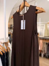 Vestido largo negro sin mangas, confeccionado en tela texturada con relieve, de corte fluido y diseño versátil.