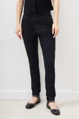 Jean de tiro medio-alto, calce skinny, con proceso de coating de acabado símil cuero y pierna al cuerpo hasta el tobillo.