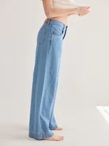 Pantalón de tiro medio alto, color beige, con bolsillos delanteros y traseros. Presenta detalles de atraques y triples costuras en color amarillo. Confeccionado en una mezcla de lino, algodón y viscosa.