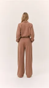 Buzo cropped de cuello alto con cordón regulable, mangas largas con puños elásticos y cintura ajustable con cordón. Presenta un diseño moderno y versátil con acabado suave.
