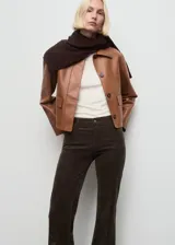Pantalón de pana estilo flare con tiro medio, cierre de botón y cremallera, trabillas para cinturón y diseño de cinco bolsillos.