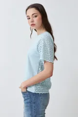 Remera fucsia de manga corta con detalle de broderie en las mangas.