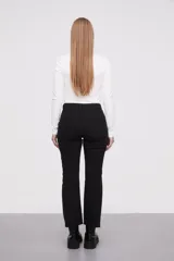 Pantalon jean de corte flare, tiro medio, con ruedo desflecado y cierre frontal con botón y cremallera.