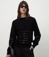 Suéter de punto color negro con cuello redondo y mangas largas. Presenta un diseño con franjas horizontales decoradas con lentejuelas del mismo tono en el cuerpo y las mangas.