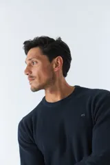 Sweater de punto color bordó, de corte clásico, cuello redondo y mangas largas. Presenta logo bordado en el pecho.