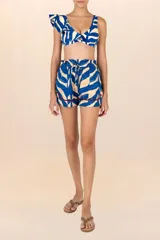Short con estampado de ondas fluidas en azul y blanco, pretina elastizada con cordón y ruedo con ribete trenzado color bordó.