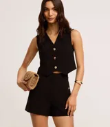 Short sastre de cintura alta color marrón, con bolsillos laterales y detalles de tachuelas metalizadas.