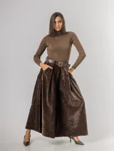Pantalón tipo palazzo de corte oversized, confeccionado en tela con textura aterciopelada en color negro. Presenta cintura alta con pinzas, bolsillos laterales y un cinturón ancho integrado con hebilla al tono.
