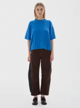 Buzo tejido de manga corta color rojo, con cuello redondo y diseño de punto acanalado y trenzado.