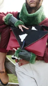 Sobre de cuero color rojo y negro con diseño de vaca y cierre con botón de guampa.