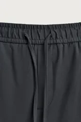 Pantalón regular fit color negro de tejido con viscosa, con cintura elástica ajustable con cordón, bolsillos frontales y traseros.