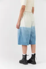 Bermuda estilo jort con diseño degradado en tonos blanco y azul, de corte ancho y largo midi con cintura elástica y cordón ajustable.