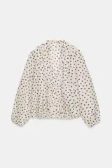 Blusa de escote en pico con volantes frontales, manga larga con puños elásticos y cierre frontal con botones.