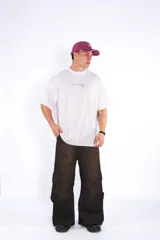 Remera de algodón blanca, corte oversize, con cuello redondo y manga corta. Presenta un pequeño estampado centrado en el pecho con texto en cursiva.