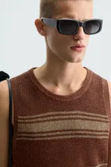 Camiseta sin mangas (manga sisa) de punto, color marrón con rayas horizontales en tono beige/tostado. Presenta cuello redondo con acabado en rib.