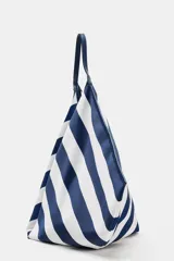 Maxi bolsa de hombro con diseño de rayas horizontales en azul marino y blanco, asa superior integrada y cierre con botón imantado.