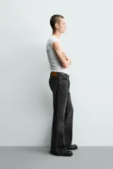 Jeans flare fit de tiro medio, confeccionados en denim de algodón color azul con efecto deslavado. Diseño ajustado en la parte superior y abierto en campana desde la rodilla, con cinco bolsillos y cierre frontal con cremallera y botón.
