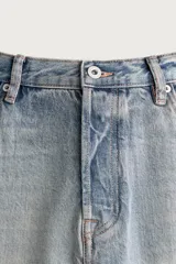 Pantalón denim de corte recto desde la cadera hasta el tobillo, de tiro medio y color celeste claro con efecto lavado. Cuenta con diseño clásico de cinco bolsillos y cierre frontal con cremallera y botón metálico.