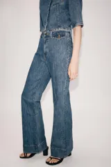 Jeans flare de tiro alto de Zara Woman Collection, en color azul con efecto lavado. Presentan un corte slim en la parte superior y perneras acampanadas con raya planchada al frente y dobladillo ancho. Incluyen cierre frontal con cremallera y botón.