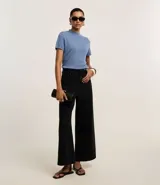 Blusa de punto color celeste, con cuello alto, manga corta y malla texturizada.