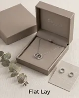 Collar de acero con cadena fina y dos dijes circulares entrelazados, uno de ellos con incrustaciones de circonias.