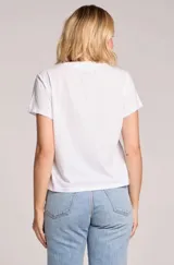 Remera blanca de manga corta y cuello redondo, con estampado frontal de casetes retro en tonos grises.