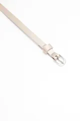 Cinturón fino color rosa pálido con hebilla metálica plateada.