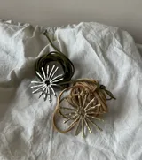 Colgante con dije en forma de sol con rayos, hecho a mano en alpaca, con cordón de gamuza marrón.