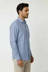 Camisa de algodón de manga larga con diseño de rayas verticales en tonos gris y blanco, cuello camisero clásico y cierre frontal con botones.