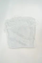 Poncho de tejido ligero con acabado brillante y flecos en los extremos.