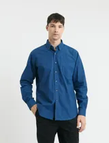 Camisa de manga larga con cuello button-down, cierre frontal con botones y bolsillo parche en el pecho. Presenta un diseño de textura sutil en color azul.