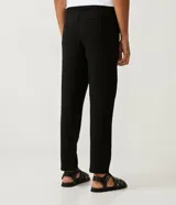 Pantalón masculino de corte slim cropped, confeccionado en viscosa con cintura elástica, bolsillos laterales y traseros, y pliegues delanteros.