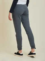 Pantalón tipo babucha de algodón y poliéster, color gris melange, con cintura elástica ajustable mediante cordón, bolsillos laterales y cierres en los tobillos.