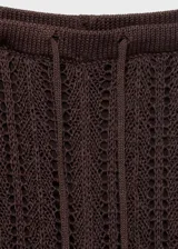 Pantalón de tiro medio confeccionado en tejido de punto calado, con diseño recto y largo. Cuenta con cintura elástica y forro interior.