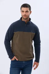 Buzo de polar texturado con diseño bicolor en azul marino y marrón, cuello alto con medio cierre y bolsillos laterales.