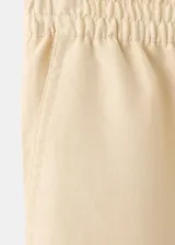 Pantalón largo color amarillo claro, de diseño balloon con cintura elástica de tiro medio y bajo con goma elástica.