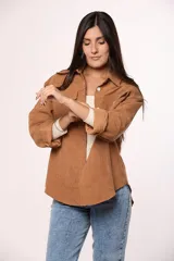 Camisa de pana fina color beige, con cuello clásico, cierre frontal de botones y dos bolsillos con solapa en el pecho.