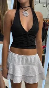 Top negro con escote halter profundo y fruncido frontal.