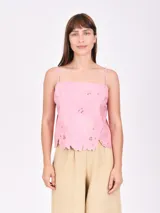 Musculosa rosa con breteles finos y detalle de calado en el ruedo.